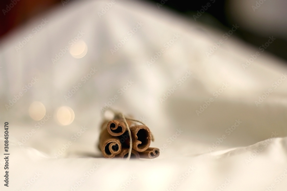 Cinnamon sticks on white background with bokeg lights. Selective focus. Cinnamon sticks on white background with bokeg lights. Selective focus.