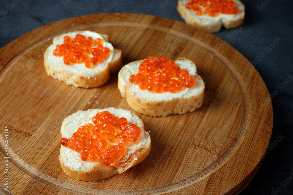 Sandwiches with red caviar on a dark background. Seafood, healthy food Sandwiches with red caviar on a dark background. Seafood, healthy food