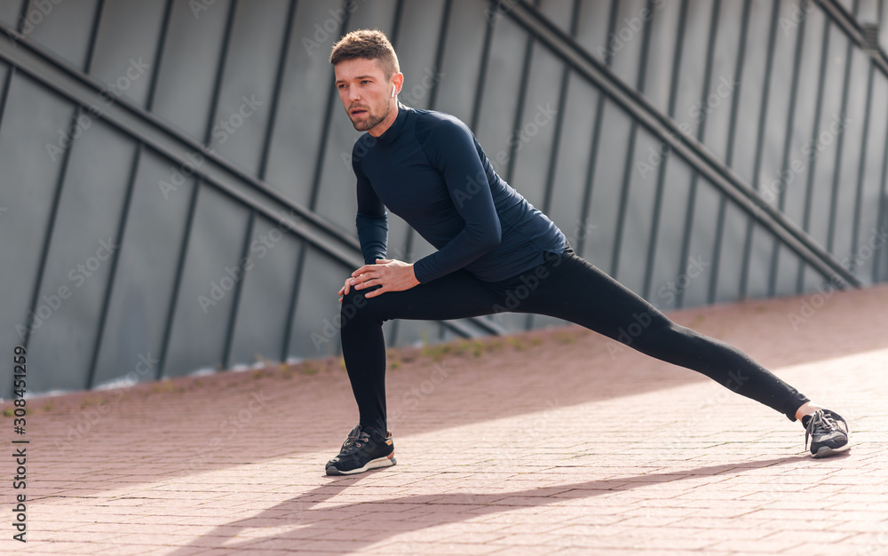 Fototapeta premium Male athlete doing warm up exercises. Sport, workout, healthy lifestyle concept.