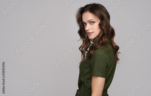Beauty young woman in green dress is smiling. Isolated