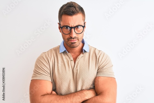 Young handsome man wearing glasses over isolated background skeptic and nervous, disapproving expression on face with crossed arms. Negative person. © Krakenimages.com