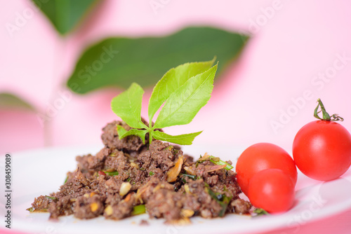 Spicy minced pork (Larb Moo) with fresh tomato, traditional northern Thai food