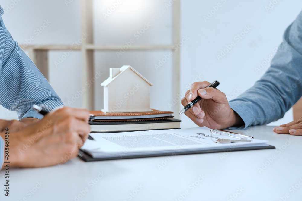 broker agent and customer holding pen, the policyholder and explain discussing for concerning mortgage loan offer for and house insurance. broker agent and customer holding pen, the policyholder and explain discussing for concerning mortgage loan offer for and house insurance.