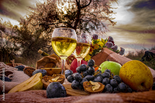 glasses with wine, fruits and nuts on a wooden board