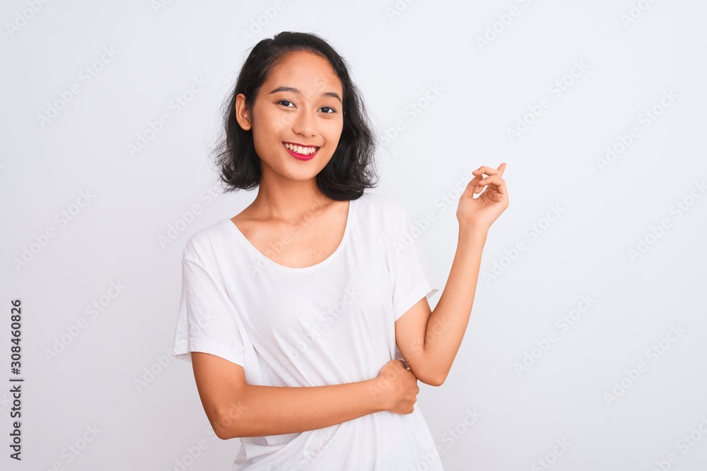 Young chinese woman wearing casual t-shirt standing over isolated white background with a big smile on face, pointing with hand and finger to the side looking at the camera. Young chinese woman wearing casual t-shirt standing over isolated white background with a big smile on face, pointing with hand and finger to the side looking at the camera.
