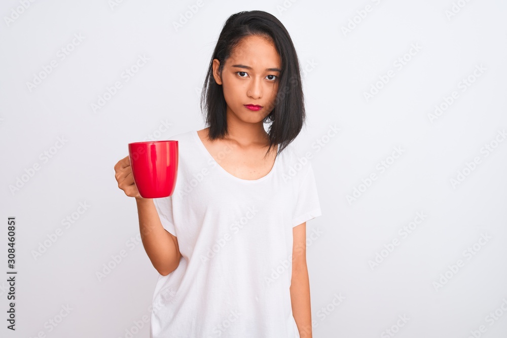 Young beautiful chinese woman drinking cup of coffee over isolated white background with a confident expression on smart face thinking serious Young beautiful chinese woman drinking cup of coffee over isolated white background with a confident expression on smart face thinking serious