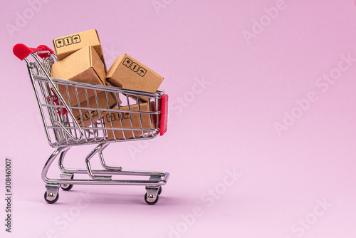 Paper boxes in shopping cart on Violet background with copy space. For online shopping business, promotion and marketing concept.
