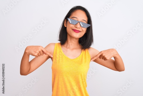 Young beautiful chinese woman wearing thug life sunglasses over isolated white background looking confident with smile on face  pointing oneself with fingers proud and happy.