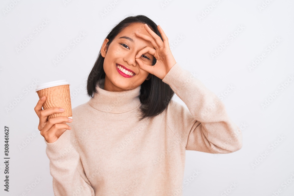 Young beautiful chinese woman drinking paper glass of coffee over isolated white background with happy face smiling doing ok sign with hand on eye looking through fingers Young beautiful chinese woman drinking paper glass of coffee over isolated white background with happy face smiling doing ok sign with hand on eye looking through fingers
