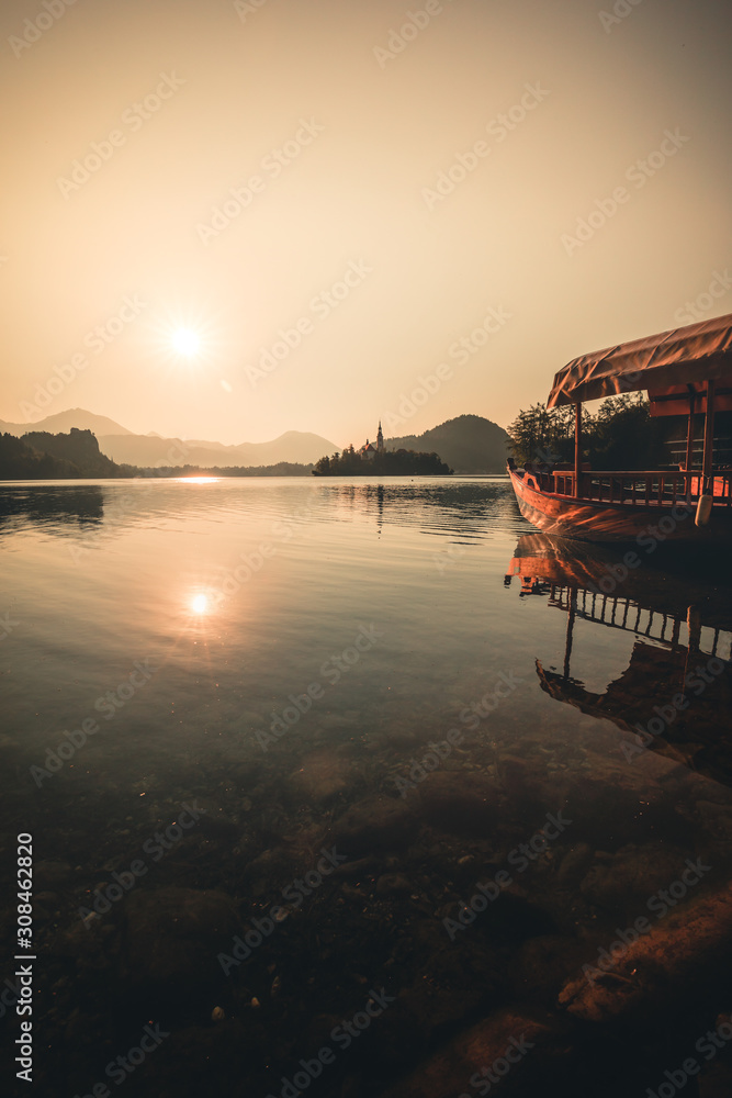 Traditional wooden boats Pletna on the backgorund of Church on the Island on Lake Bled, Slovenia. Europe.