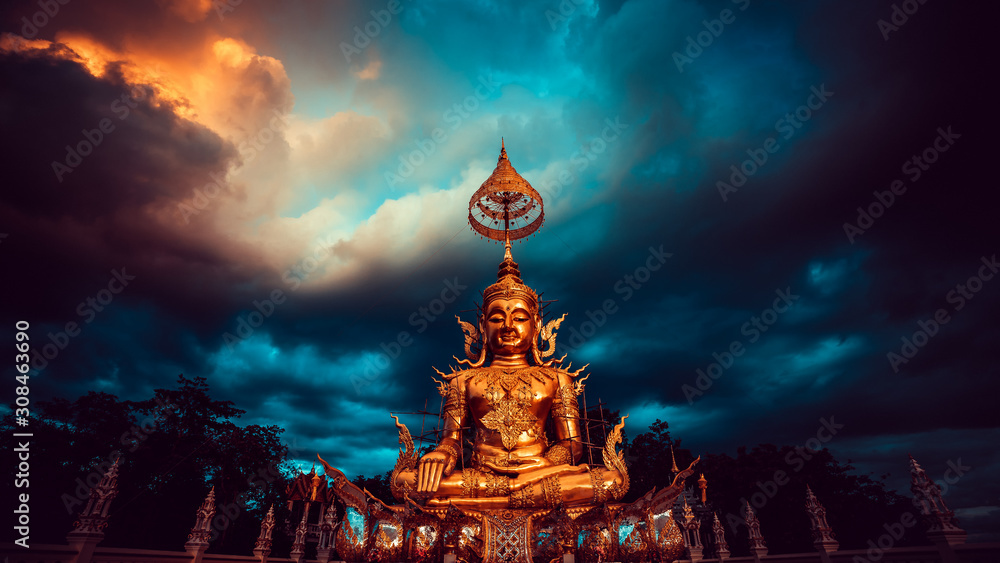 Buddha statue in Thailand temple on background dramatic cloudy sky. Asian culture and religion