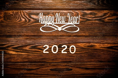 Happy new year 2020 on wooden brown background.