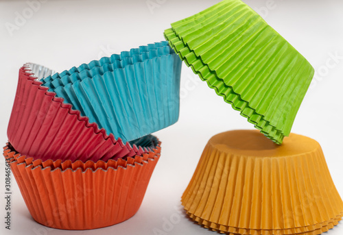 Colorful cupcake wrappers stacked on a white background