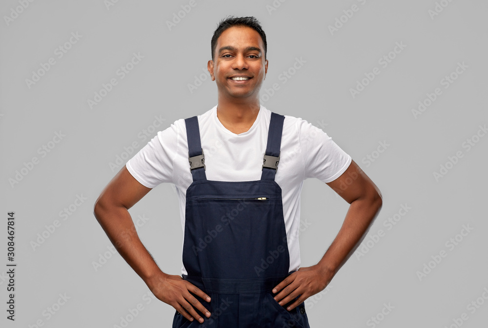 Fototapeta premium profession, construction and building - happy smiling indian worker or builder over grey background