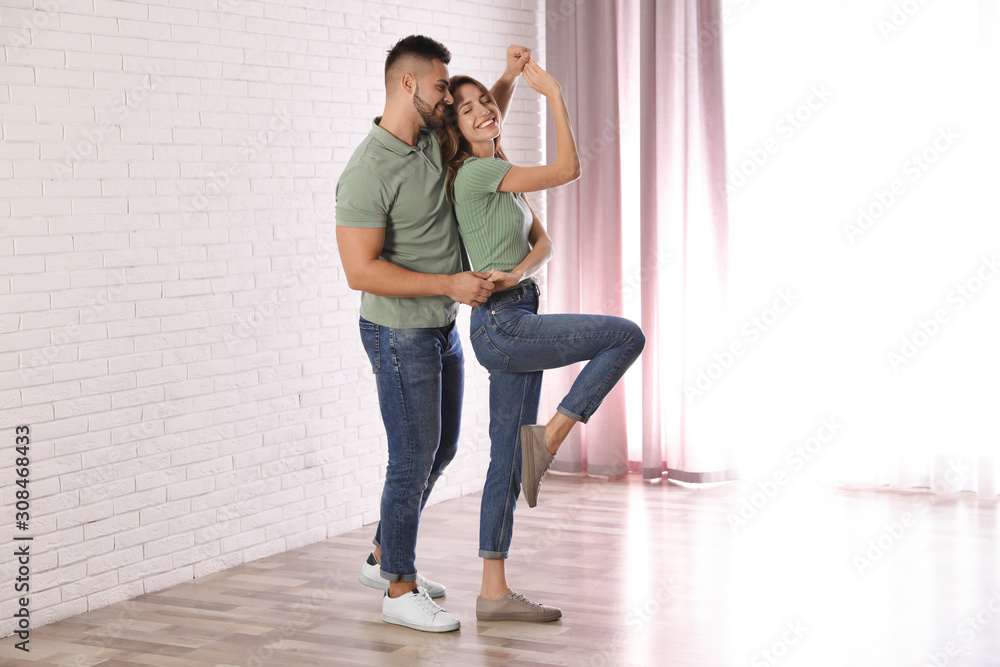 Lovely young couple dancing together at home Lovely young couple dancing together at home