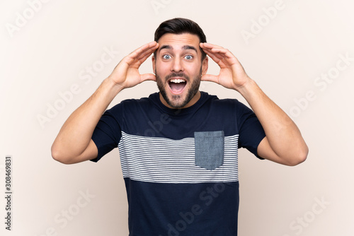 Young handsome man with beard over isolated background with surprise expression