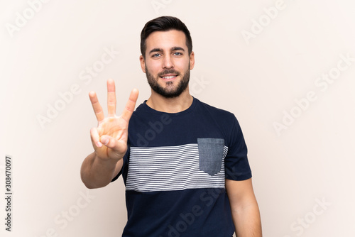 Young handsome man with beard over isolated background happy and counting three with fingers © luismolinero
