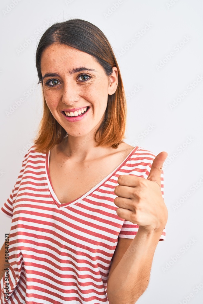 Beautiful redhead woman wearing casual striped red t-shirt over isolated background happy with big smile doing ok sign, thumb up with fingers, excellent sign