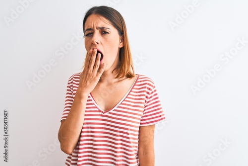 Beautiful redhead woman wearing casual striped red t-shirt over isolated background bored yawning tired covering mouth with hand. Restless and sleepiness.