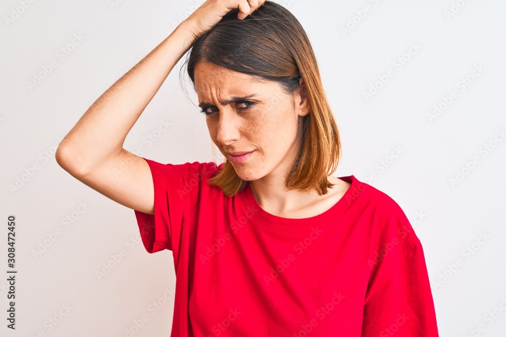 Beautiful redhead woman wearing casual red t-shirt over isolated background confuse and wonder about question. Uncertain with doubt, thinking with hand on head. Pensive concept. Beautiful redhead woman wearing casual red t-shirt over isolated background confuse and wonder about question. Uncertain with doubt, thinking with hand on head. Pensive concept.