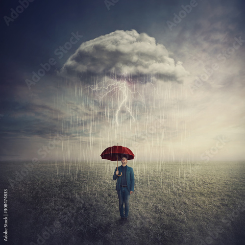 Φωτογραφία Surreal scene as man stands outdoors under umbrella due a single mysterious storm cloud raining only over him