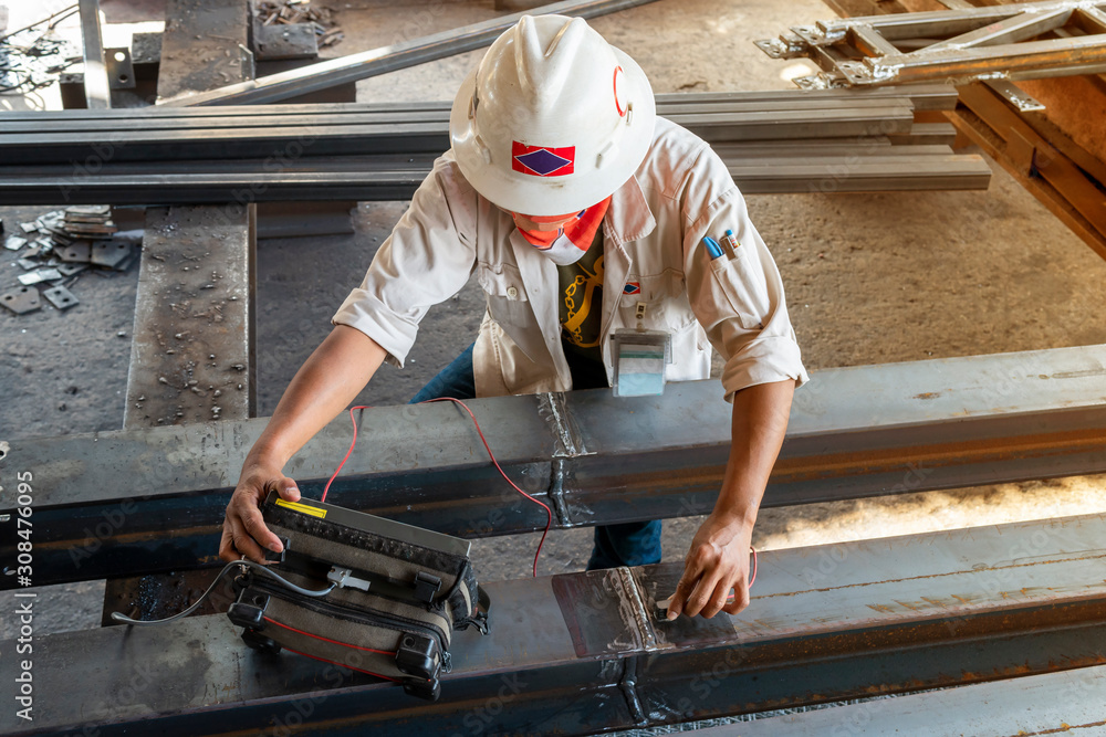 The inspectors are checking defect in welded of steel add joint with ...