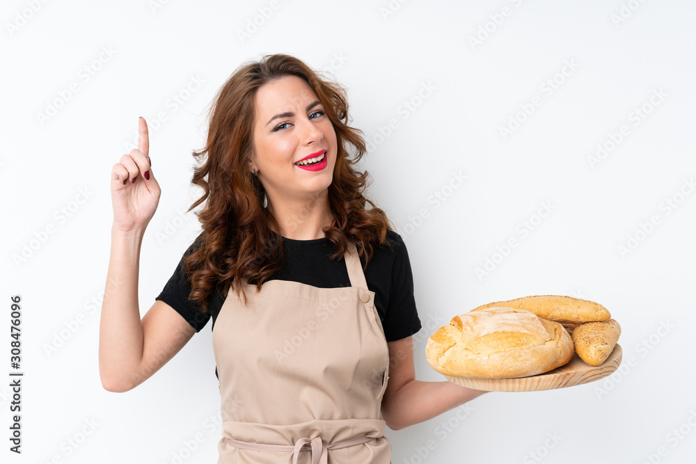 Woman in chef uniform. Female baker holding a table with several breads pointing up a great idea Woman in chef uniform. Female baker holding a table with several breads pointing up a great idea