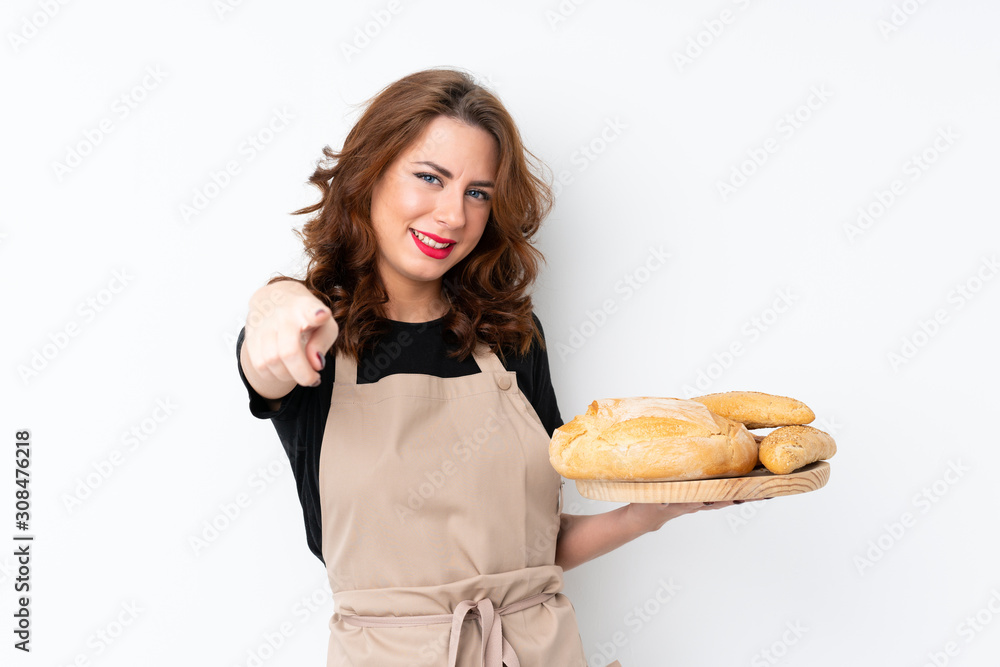 Woman in chef uniform. Female baker holding a table with several breads points finger at you with a confident expression Woman in chef uniform. Female baker holding a table with several breads points finger at you with a confident expression