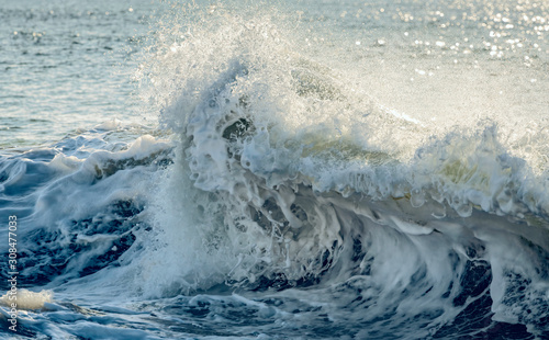 Close up of a wave crashing on a beach in Molokai, Hawaii.