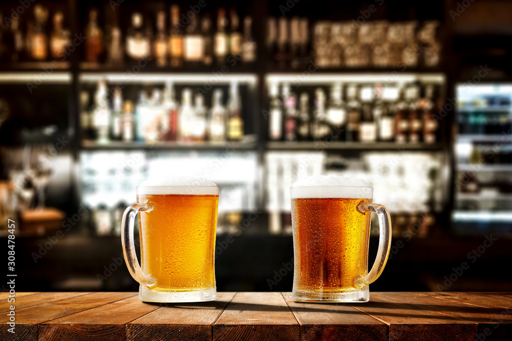 Glass of beer on wooden board and blurred bar background.Free space for your decoration. 