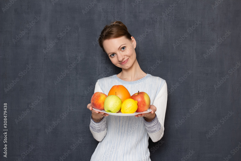Portrait of happy cheerful girl holding plate with ripe fresh fruits Portrait of happy cheerful girl holding plate with ripe fresh fruits