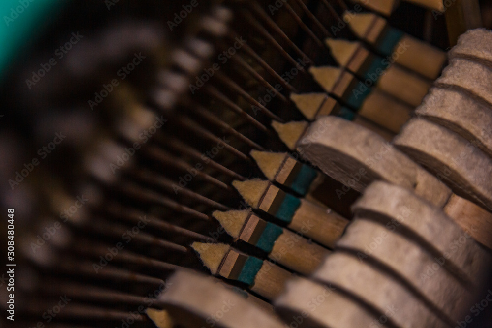 Close up of old broken dusty piano from the inside. Hammers in abandoned piano striking strings. Music playing from the ancient ruined piano. Gavel of the string open mechanism. Close up of old broken dusty piano from the inside. Hammers in abandoned piano striking strings. Music playing from the ancient ruined piano. Gavel of the string open mechanism.