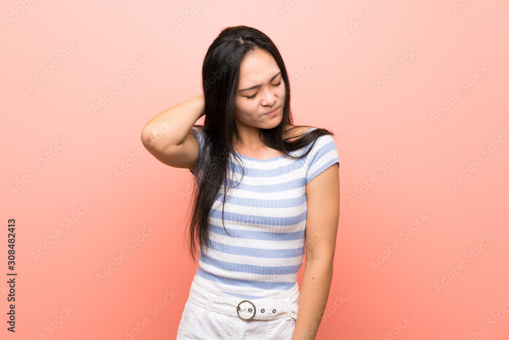 Teenager asian girl over isolated pink background with neckache Teenager asian girl over isolated pink background with neckache