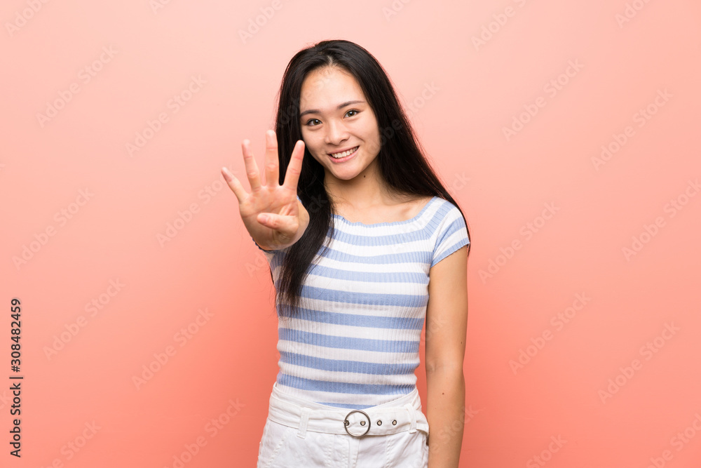 Teenager asian girl over isolated pink background happy and counting four with fingers Teenager asian girl over isolated pink background happy and counting four with fingers