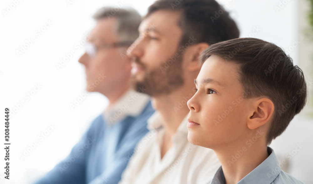 Portrait Of Boy, Father And Grandfather Sitting At Home, Side-View Portrait Of Boy, Father And Grandfather Sitting At Home, Side-View