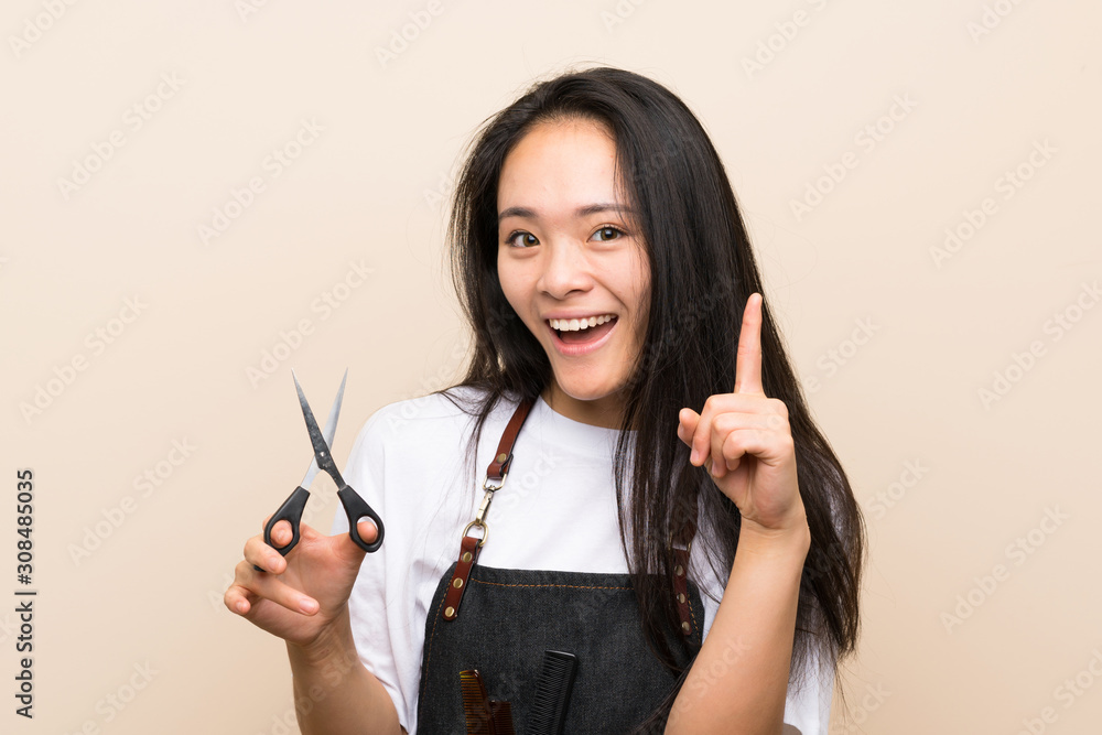Obraz premium Teenager hairdresser girl pointing up a great idea