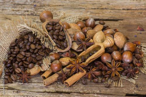 coffee beans, nuts and spices on old wooden background
