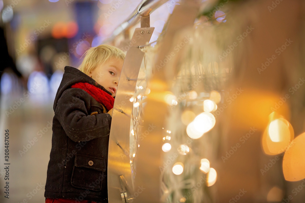 Fashion toddler boy in the city center shopping mall on Christmas