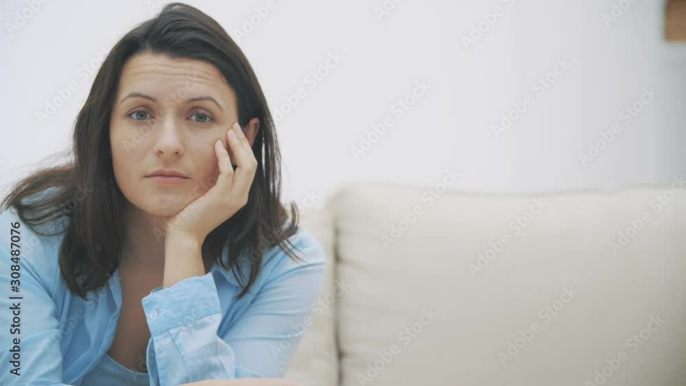 Slowmo. Attractive woman is watching TV. She hears surprising information and raises her eyebrows. Close up. Copy space. 4K. Slowmo. Attractive woman is watching TV. She hears surprising information and raises her eyebrows. Close up. Copy space. 4K.
