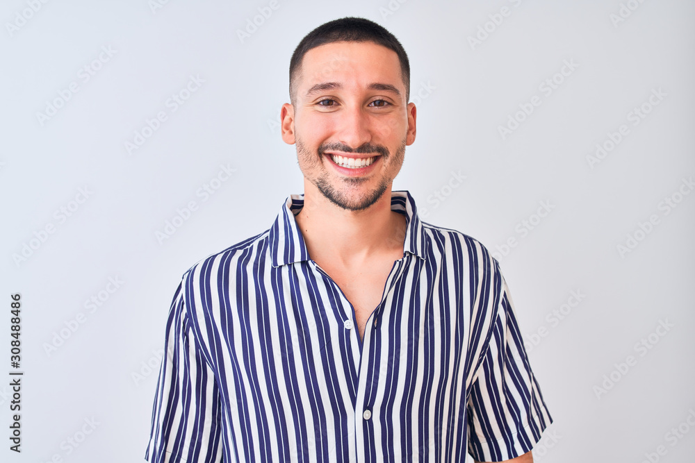 Young handsome man wearing nautical striped shirt standing over isolated background with a happy and cool smile on face. Lucky person.