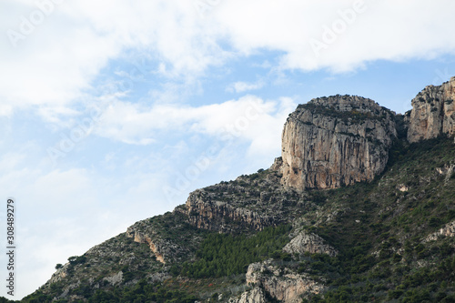 Monaco mountain with blue sky and green trees.