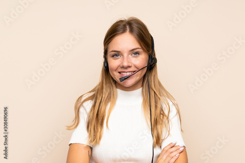 Young blonde woman over isolated background working with headset