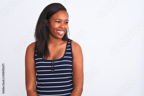 Beautiful young african american woman wearing summer t-shirt over isolated background looking away to side with smile on face, natural expression. Laughing confident. © Krakenimages.com