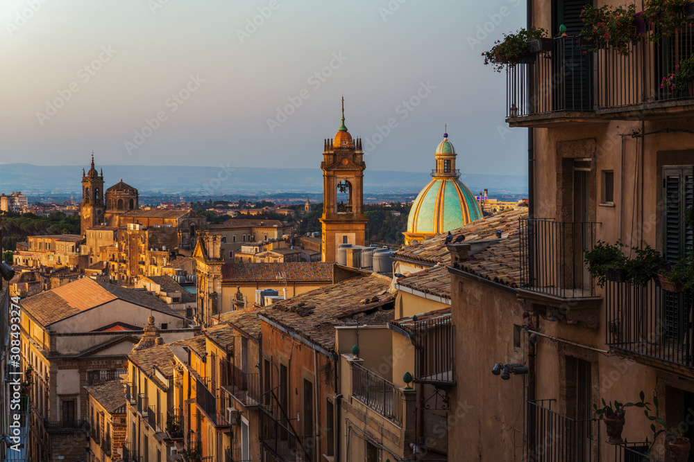 Sunrise and city view of the typical italian roofs and dome of cathedral in the colorful sicilian village Caltagirone in Sicily, south Italy