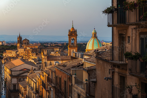 Sunrise and city view of the typical italian roofs and dome of cathedral in the colorful sicilian village Caltagirone in Sicily, south Italy