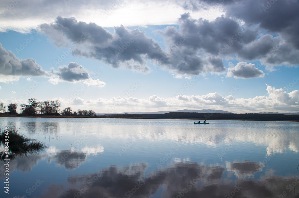 Obraz premium Canoe rowers on the lake with reflection, Igneada Turkey