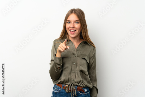Lithuanian blonde girl over isolated white background surprised and pointing front © luismolinero