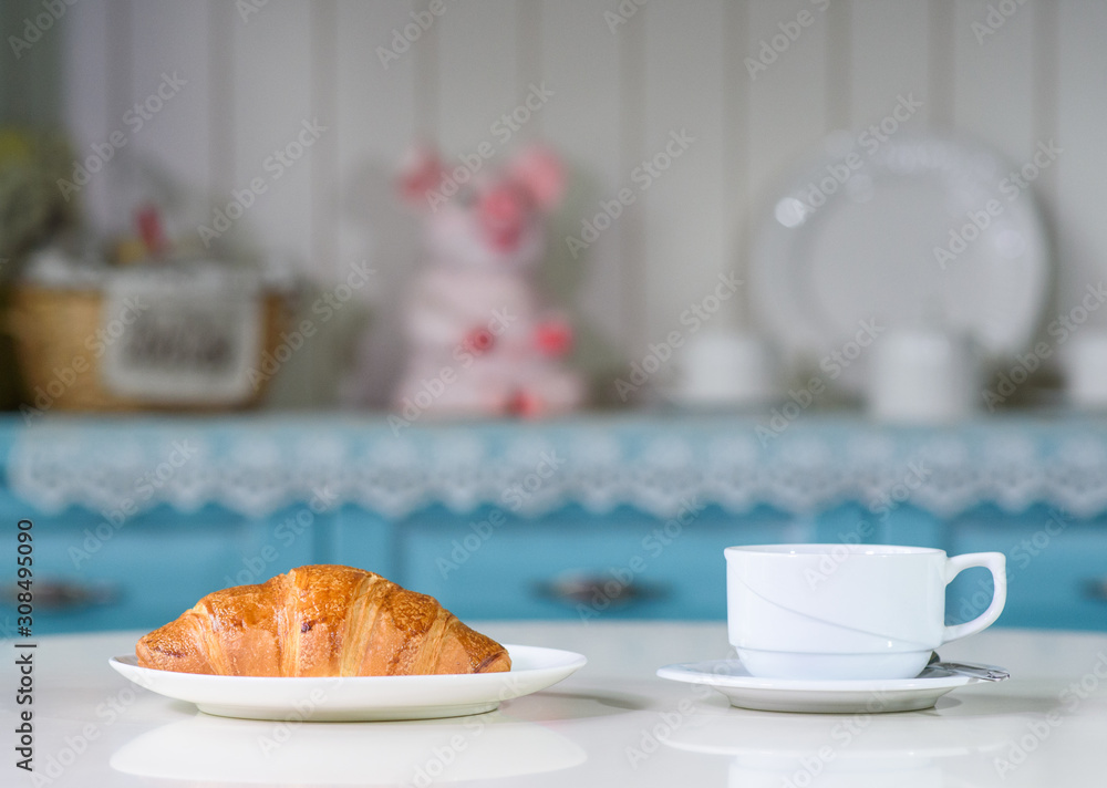 Fruit tea and delicious fresh croissant on the table in a cozy coffee shop Fruit tea and delicious fresh croissant on the table in a cozy coffee shop