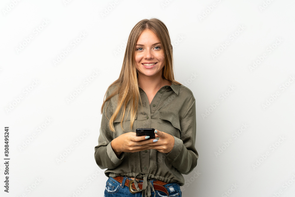 Lithuanian blonde girl over isolated white background sending a message with the mobile