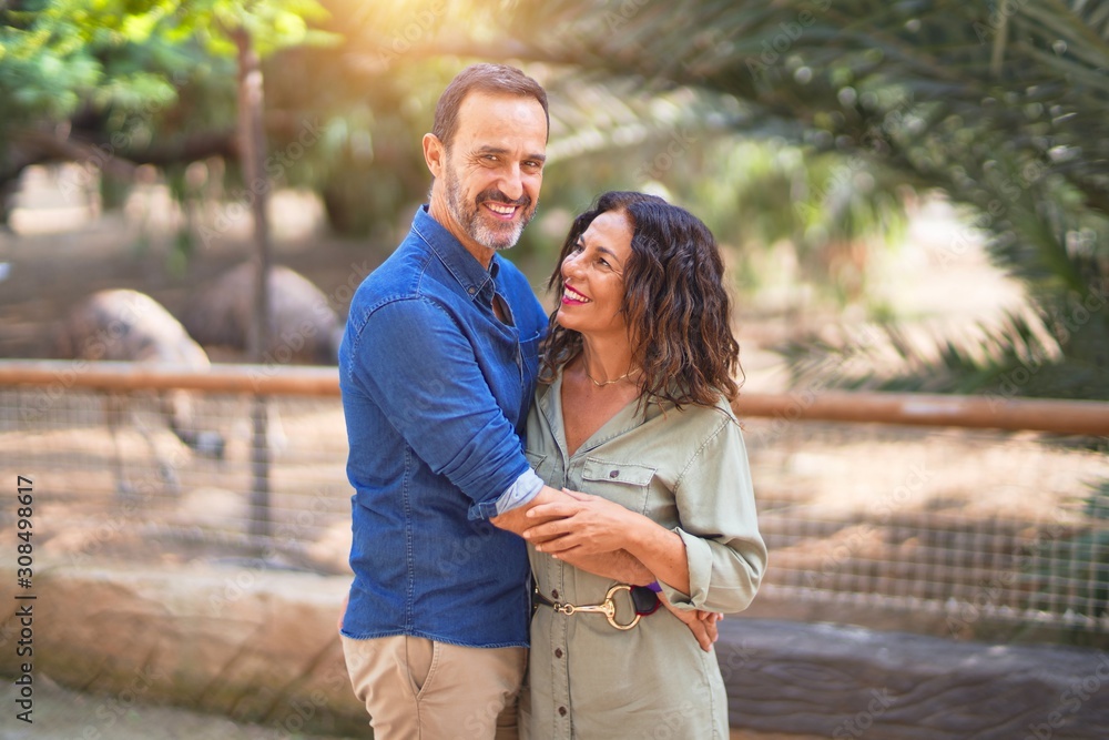 Middle age beautiful couple smiling happy and confident at town park. Standing with smile on face and hugging Middle age beautiful couple smiling happy and confident at town park. Standing with smile on face and hugging